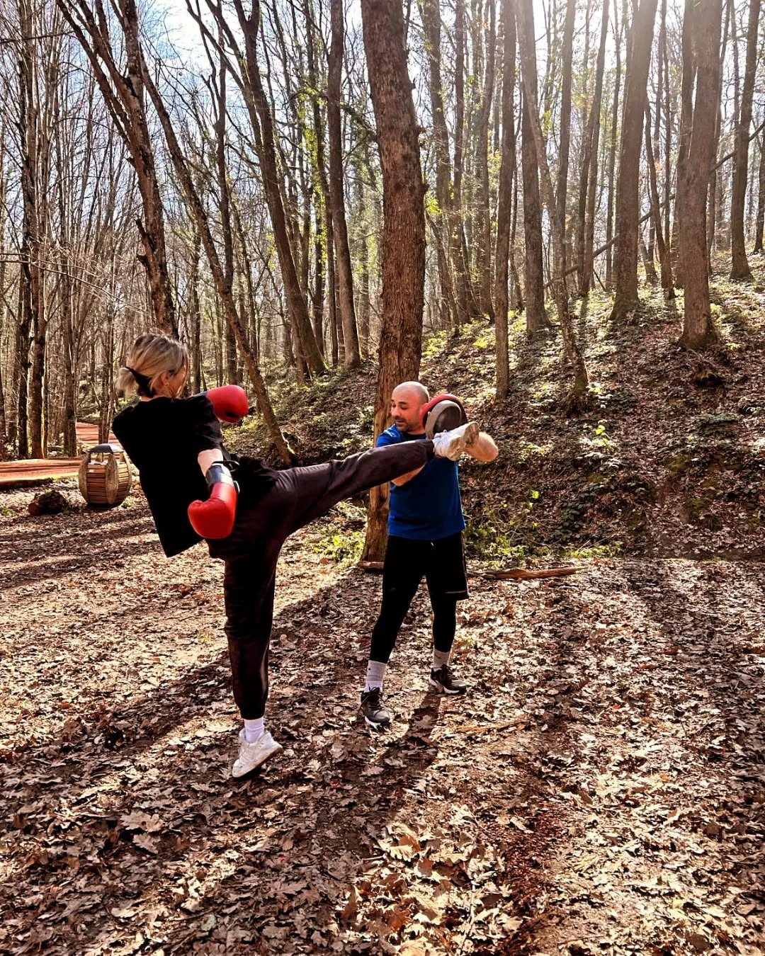Ormanda açık havada yüksek tekme tekniği çalışan iki sporcu